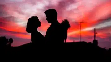 silhouette of man and woman facing each other during golden hour