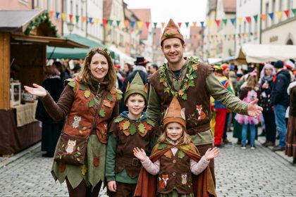 Famille en costumes de carnaval sur rue lors d'un carnaval forestier